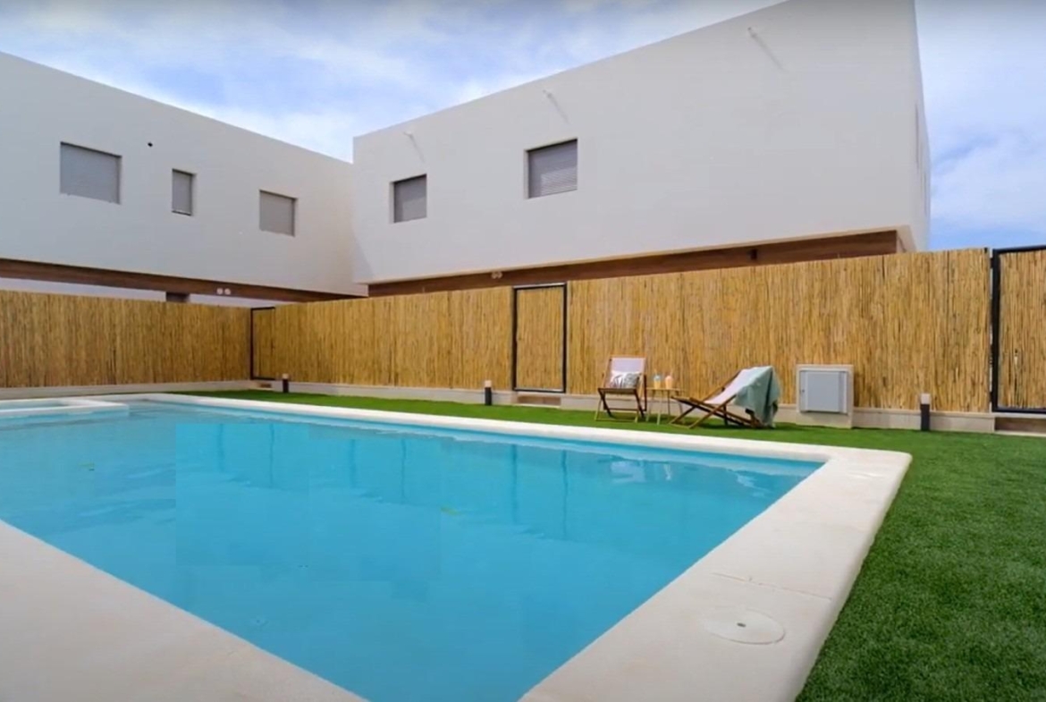 Modern new build 3-bedroom property in Orihuela Costa featuring a pristine communal pool and stylish exterior near the beach.