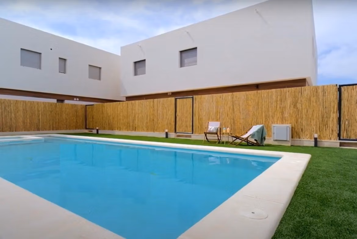 Spacious communal pool with modern landscaped surroundings at a 2-bedroom townhouse in Orihuela Costa near the beach