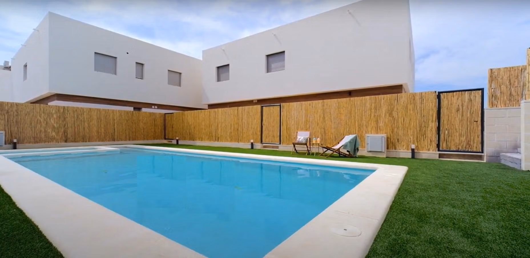 Spacious communal pool with modern landscaped surroundings at a 2-bedroom townhouse in Orihuela Costa near the beach