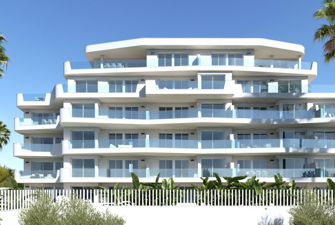 Modern white luxury apartment building with spacious terraces and palm trees near the sea in Mil Palmeras.