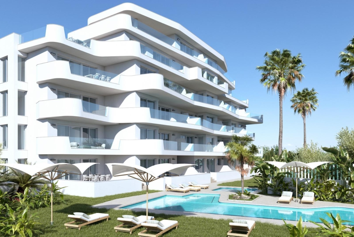 Modern luxury 2-bedroom ground floor apartment in Mil Palmeras with sleek white exterior, landscaped gardens, and inviting pool area.