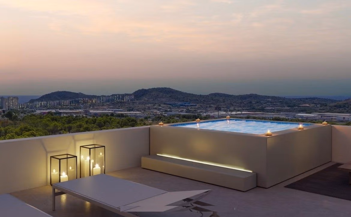 Sunset view of a sleek rooftop terrace with an illuminated jacuzzi and loungers in a modern 3-bedroom apartment, Sierra Cortina, Finestrat.