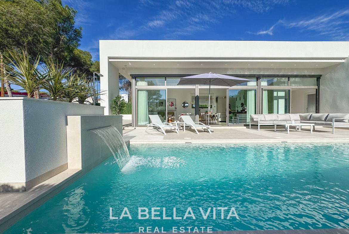 Sun-drenched modern 3-bedroom villa in Pinar de Campoverde with private pool, spacious terrace, and sleek glass facade.