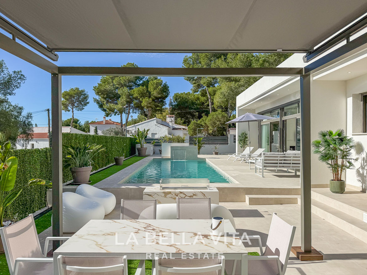 Modern 3-bedroom villa in Pinar de Campoverde featuring a serene sunlit pool, stylish outdoor terrace, and lush landscaped garden.