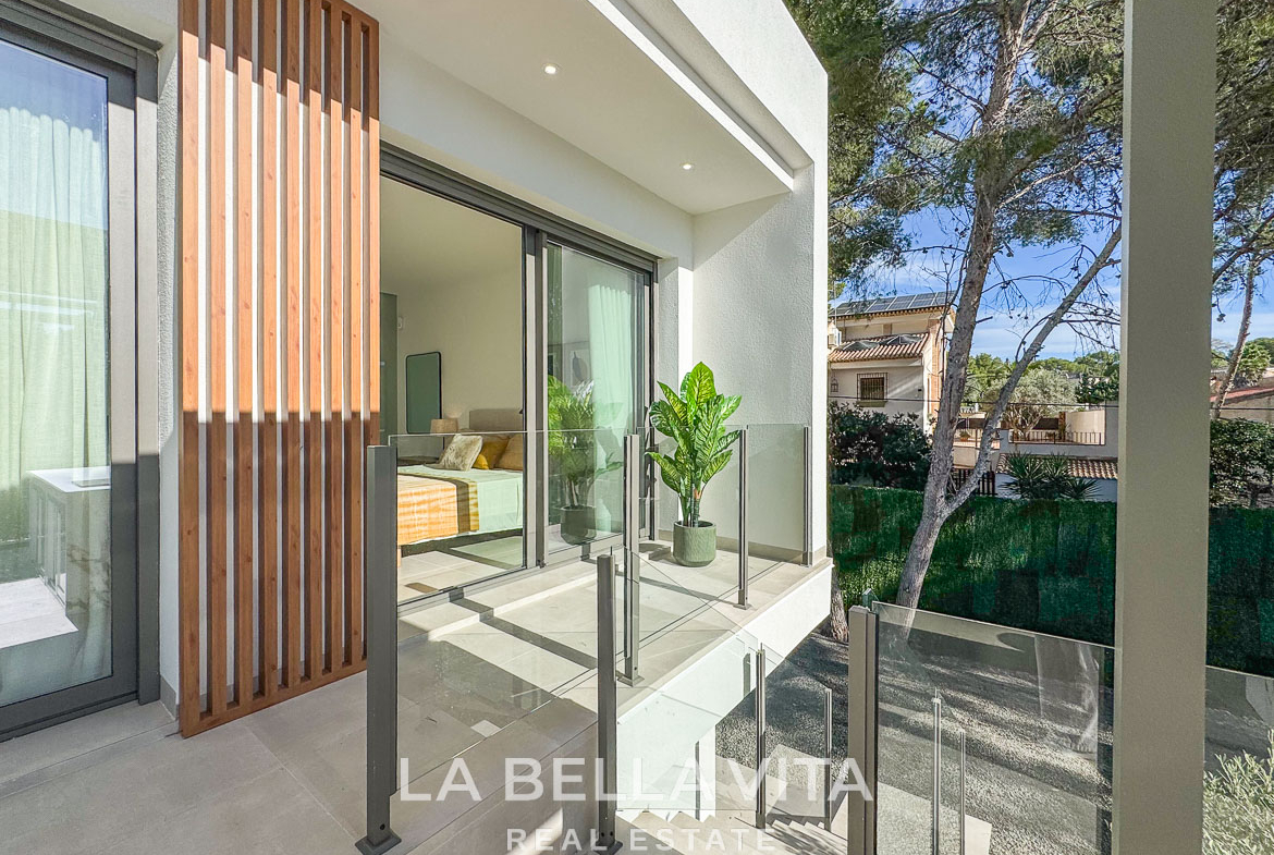 Bright modern terrace with glass railing overlooking lush greenery in impressive new build 3-bedroom villa, Pinar de Campoverde.