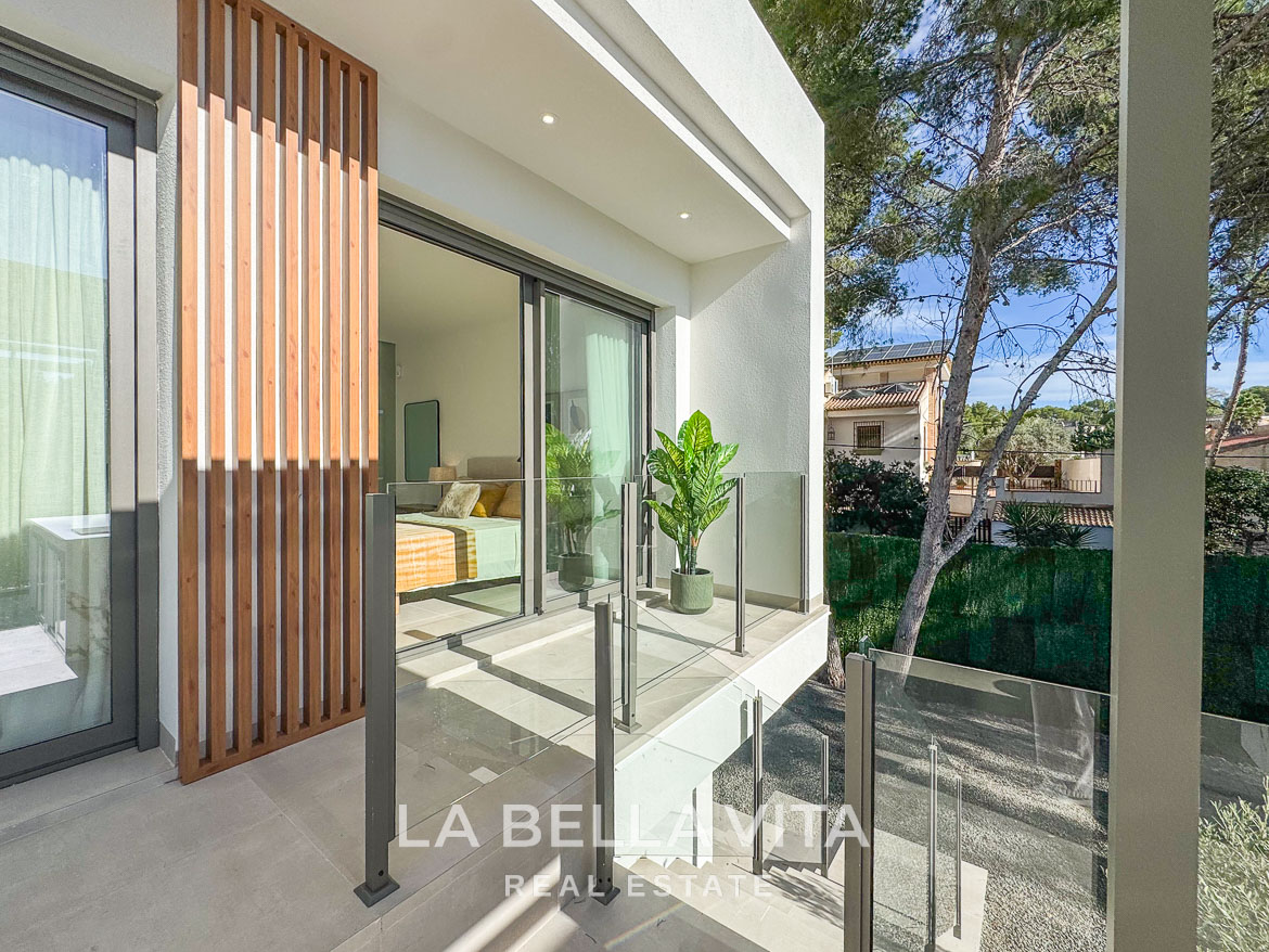 Bright modern terrace with glass railing overlooking lush greenery in impressive new build 3-bedroom villa, Pinar de Campoverde.