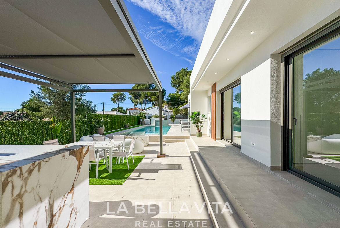 Sun-drenched modern terrace with outdoor dining and pool at exquisite 3-bedroom villa in Pinar de Campoverde
