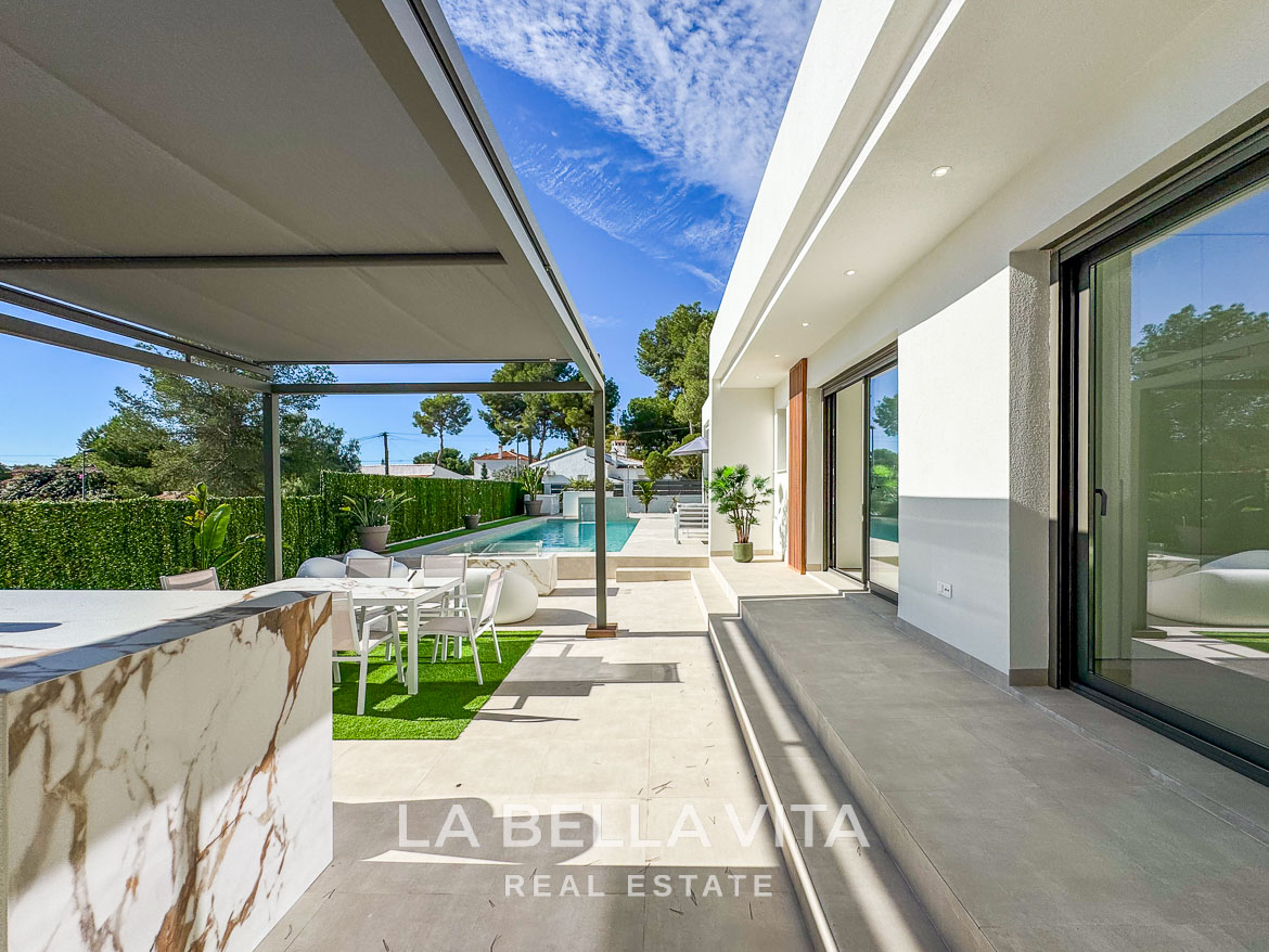 Sun-drenched modern terrace with outdoor dining and pool at exquisite 3-bedroom villa in Pinar de Campoverde