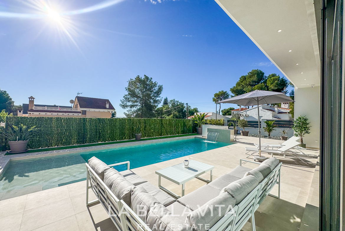 Sun-drenched modern villa poolside terrace with sleek outdoor seating and landscaped privacy in Pinar de Campoverde luxury 3-bedroom home.