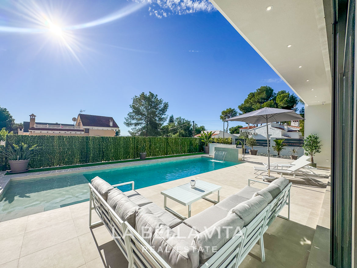 Sun-drenched modern villa poolside terrace with sleek outdoor seating and landscaped privacy in Pinar de Campoverde luxury 3-bedroom home.