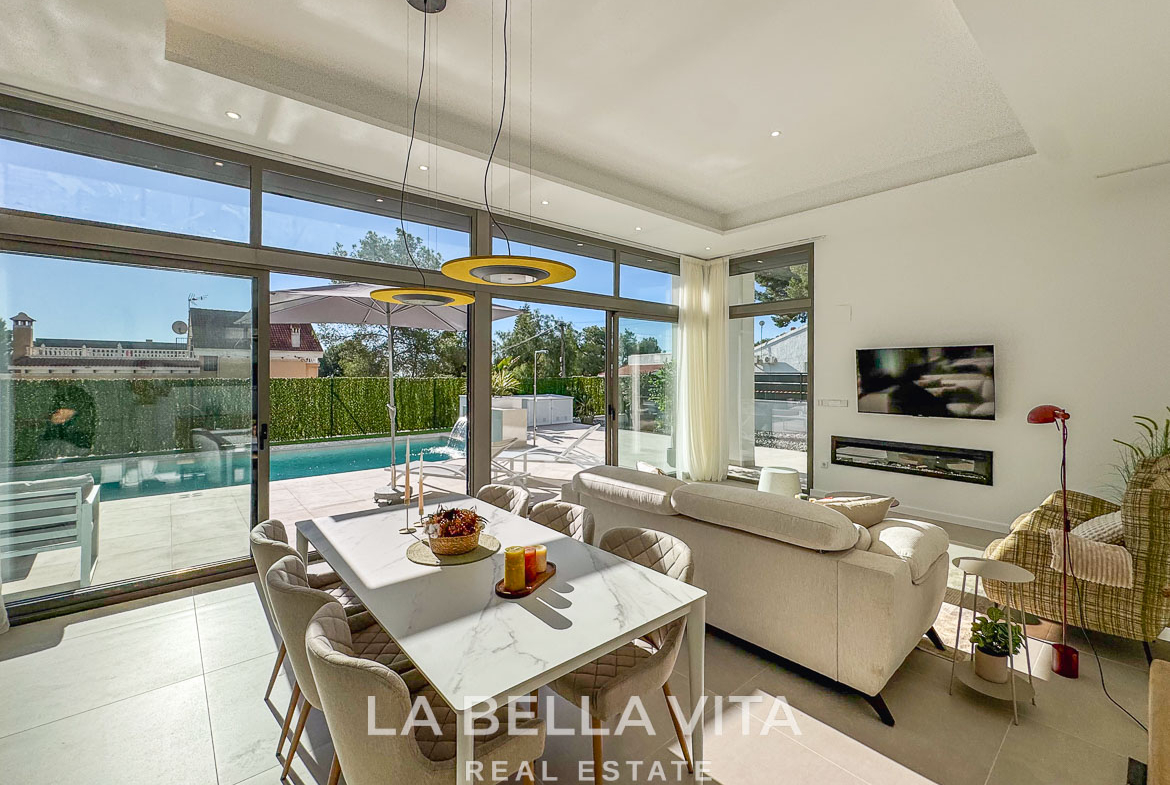 Bright, modern open-plan living and dining area with sleek furnishings and pool views in a 3-bedroom villa in Pinar de Campoverde.