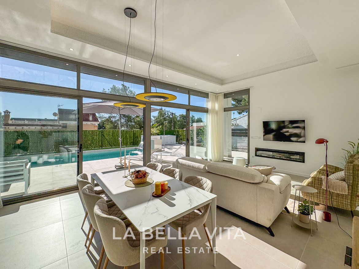 Bright, modern open-plan living and dining area with sleek furnishings and pool views in a 3-bedroom villa in Pinar de Campoverde.