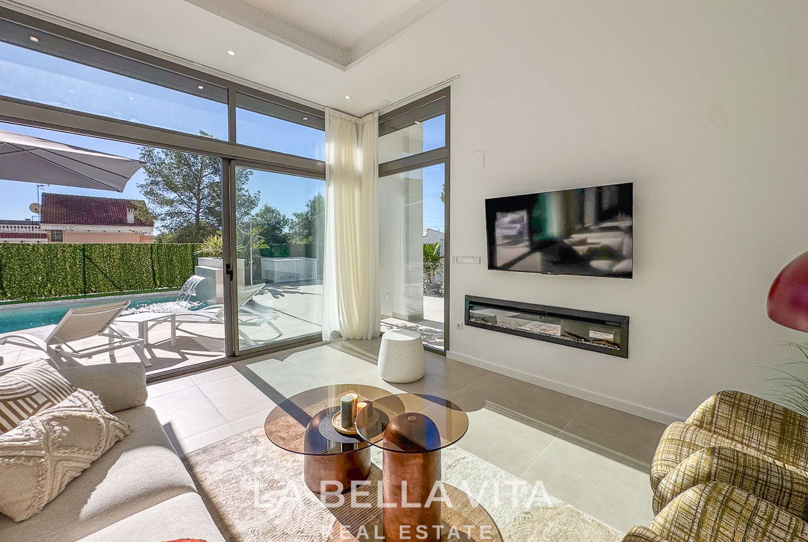 Bright, modern living room with floor-to-ceiling windows and pool view in a stunning 3-bedroom villa in Pinar de Campoverde.
