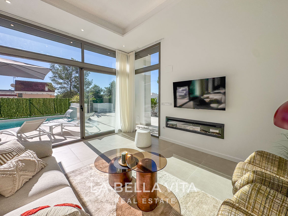 Bright, modern living room with floor-to-ceiling windows and pool view in a stunning 3-bedroom villa in Pinar de Campoverde.