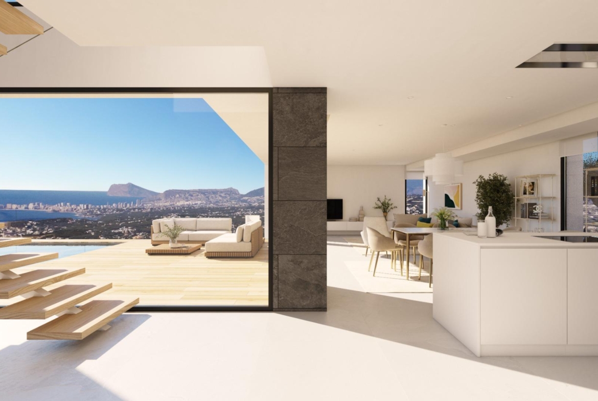 Bright modern kitchen and open-plan living area with floating staircase and sun-drenched terrace in luxury villa at Cumbre del Sol