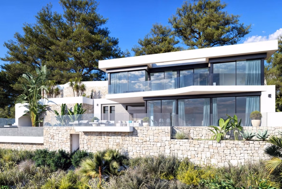 Modern 4-bedroom villa in Benissa Costa with sleek glass façade, landscaped terraces, and lush Mediterranean surroundings.