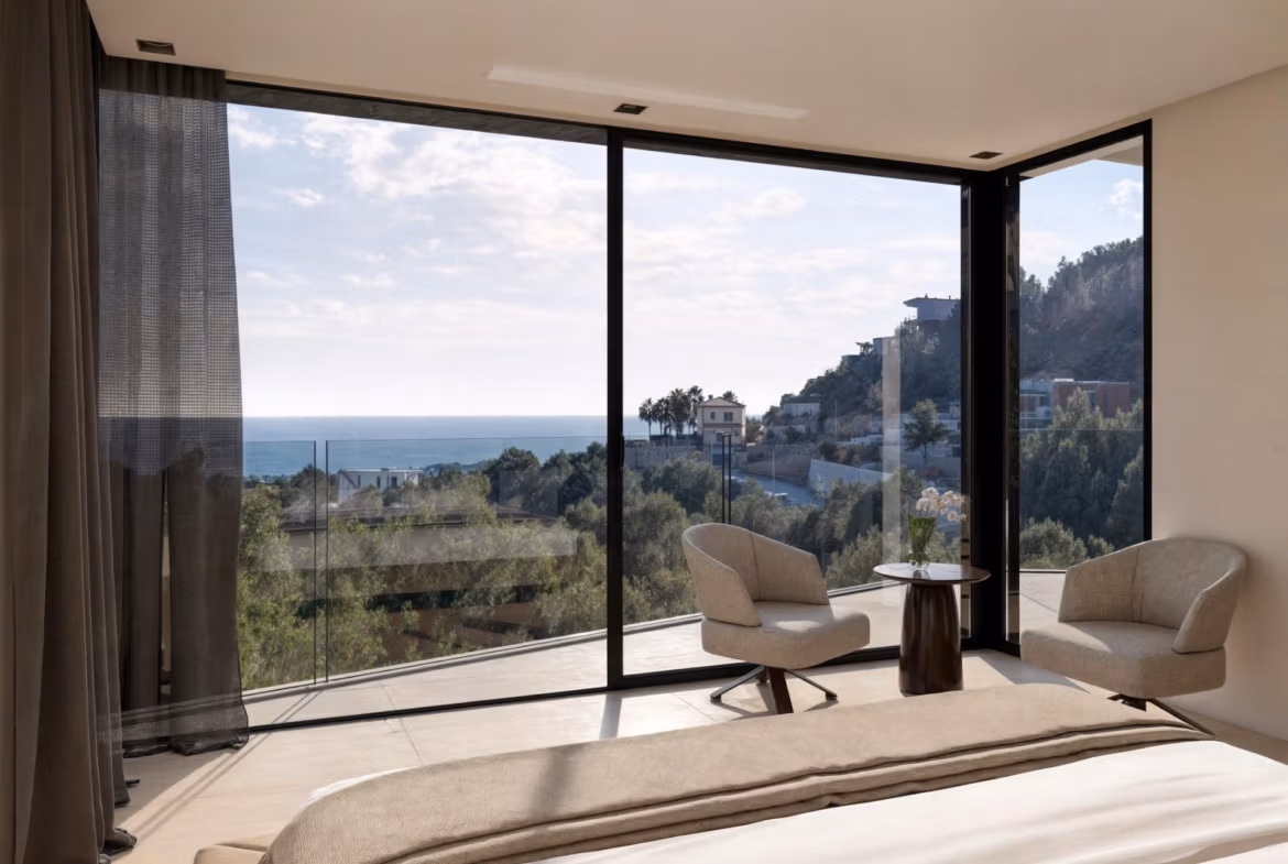 Bright, elegant bedroom in new build 4-bedroom villa in Benissa Costa with panoramic sea views through floor-to-ceiling windows