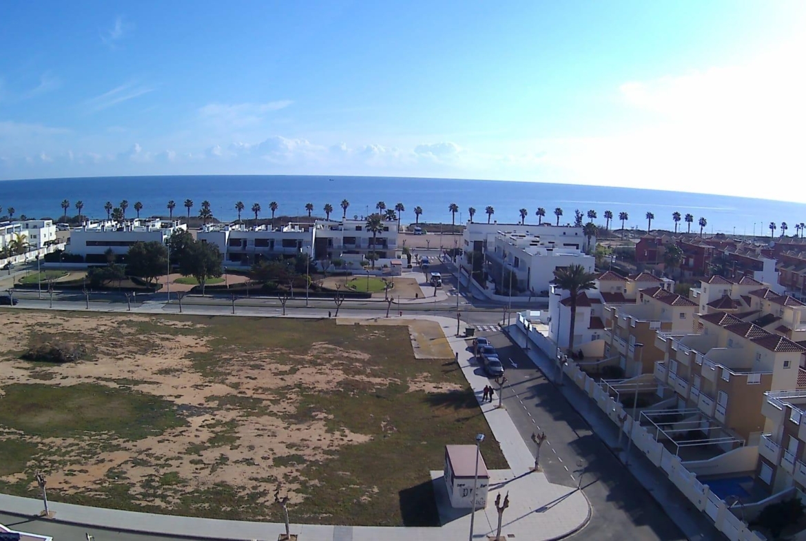 Spacious modern new build apartment exterior with private garden, sunlit streets, and panoramic sea views in Torre de la Horadada