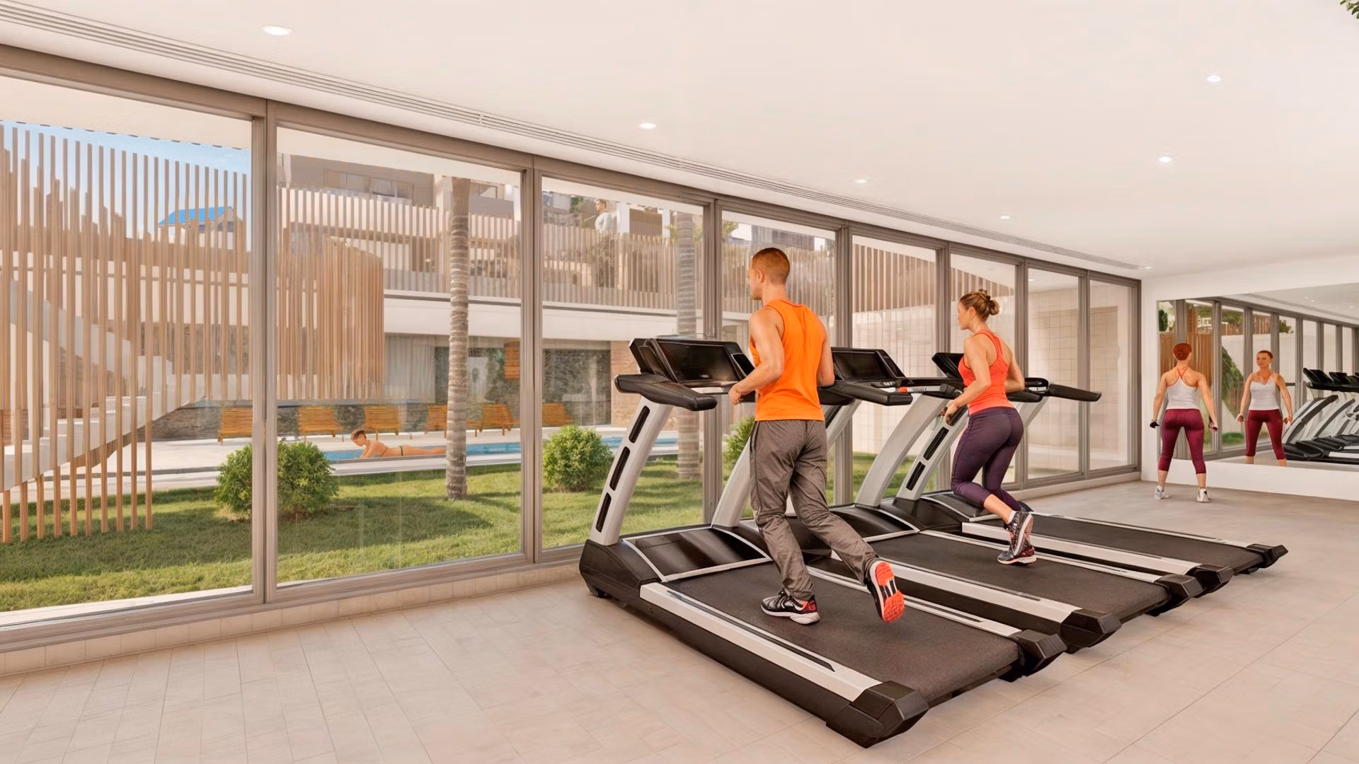 Bright modern gym with floor-to-ceiling windows in exclusive Torre de la Horadada penthouse complex, offering serene outdoor views.