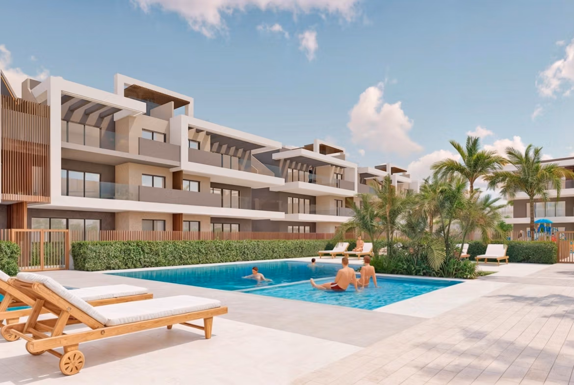 Modern luxury 3-bedroom apartment complex in Torre de la Horadada with a spacious, sunlit pool area and landscaped surroundings.