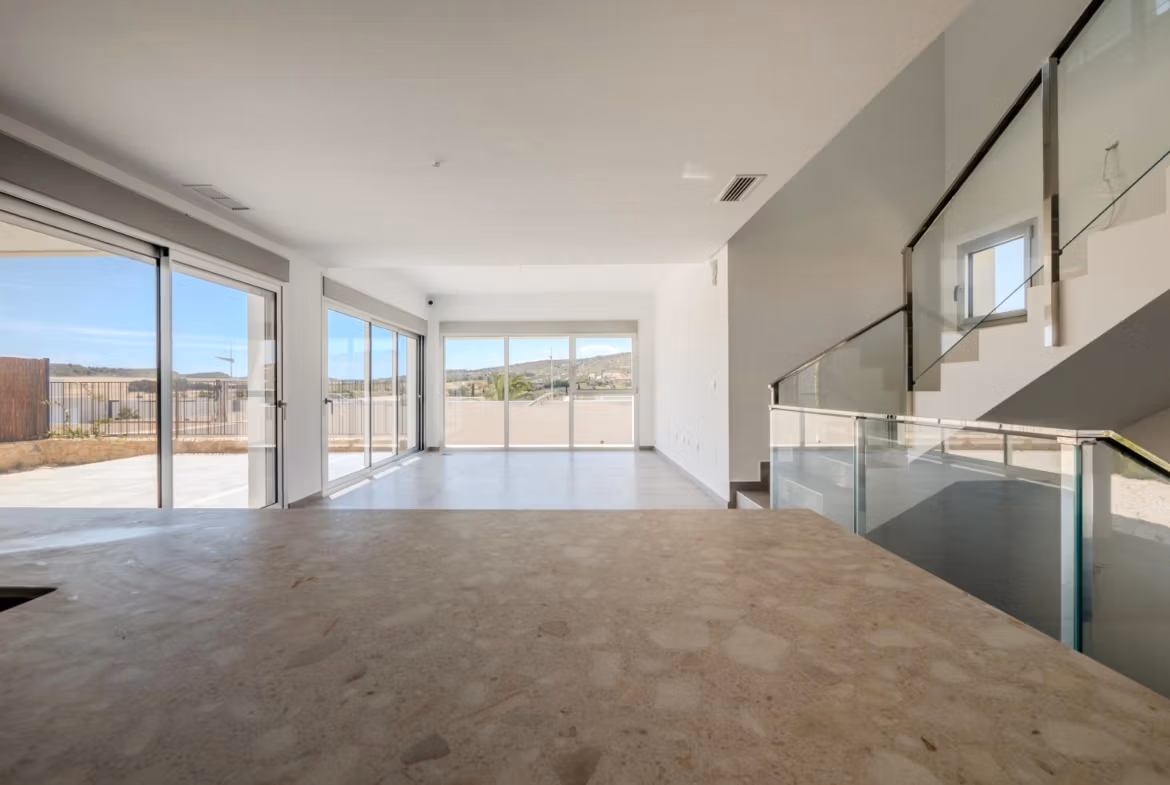 Bright open-plan living area with floor-to-ceiling windows showcasing panoramic golf views in a modern 4-bedroom villa in Algorfa, La Finca.