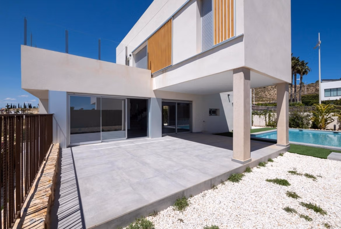 Modern 4-bedroom villa exterior in Algorfa with spacious sunlit terrace and private pool, showcasing sleek architectural design.