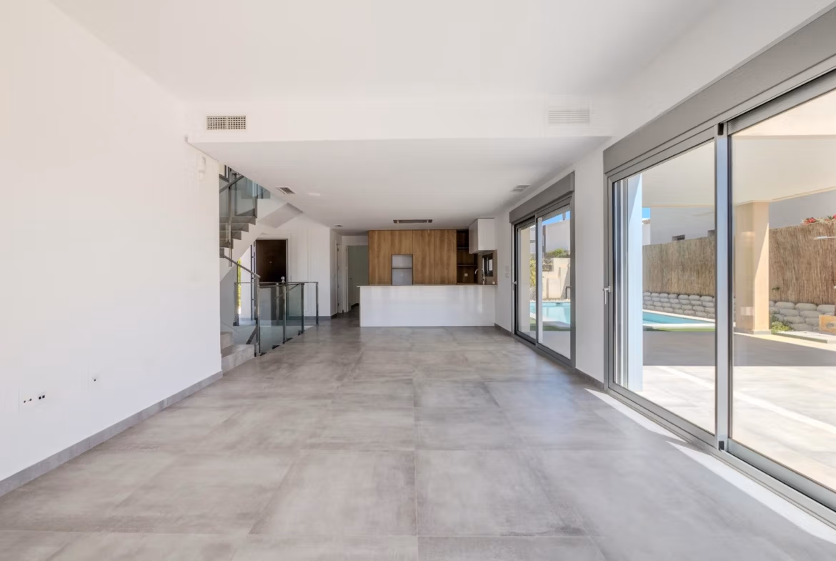 Bright spacious open-plan living area with modern kitchen and large sliding doors opening to the terrace of a luxury 4-bedroom villa in Algorfa