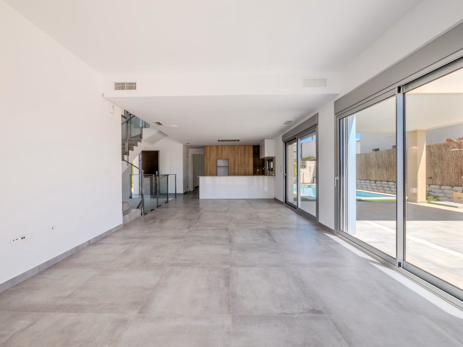 Bright spacious open-plan living area with modern kitchen and large sliding doors opening to the terrace of a luxury 4-bedroom villa in Algorfa