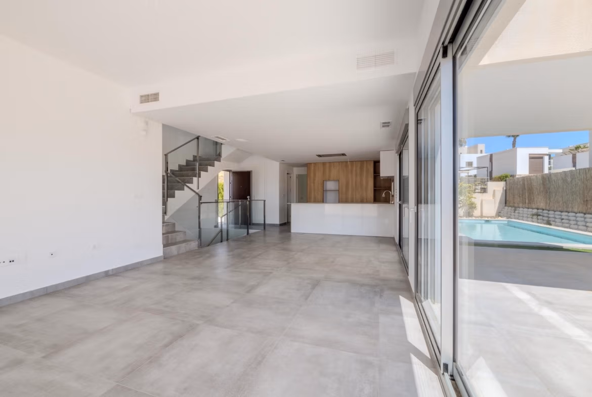 Bright open-plan living area with sleek kitchen and large glass doors overlooking private pool in luxury Algorfa villa