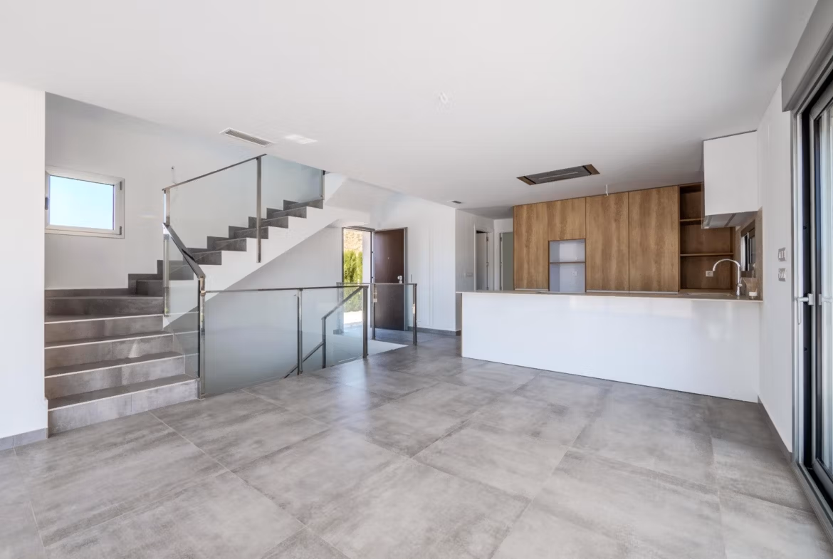 Bright modern open-plan kitchen and living area with sleek staircase in 4-bedroom villa in Algorfa, La Finca
