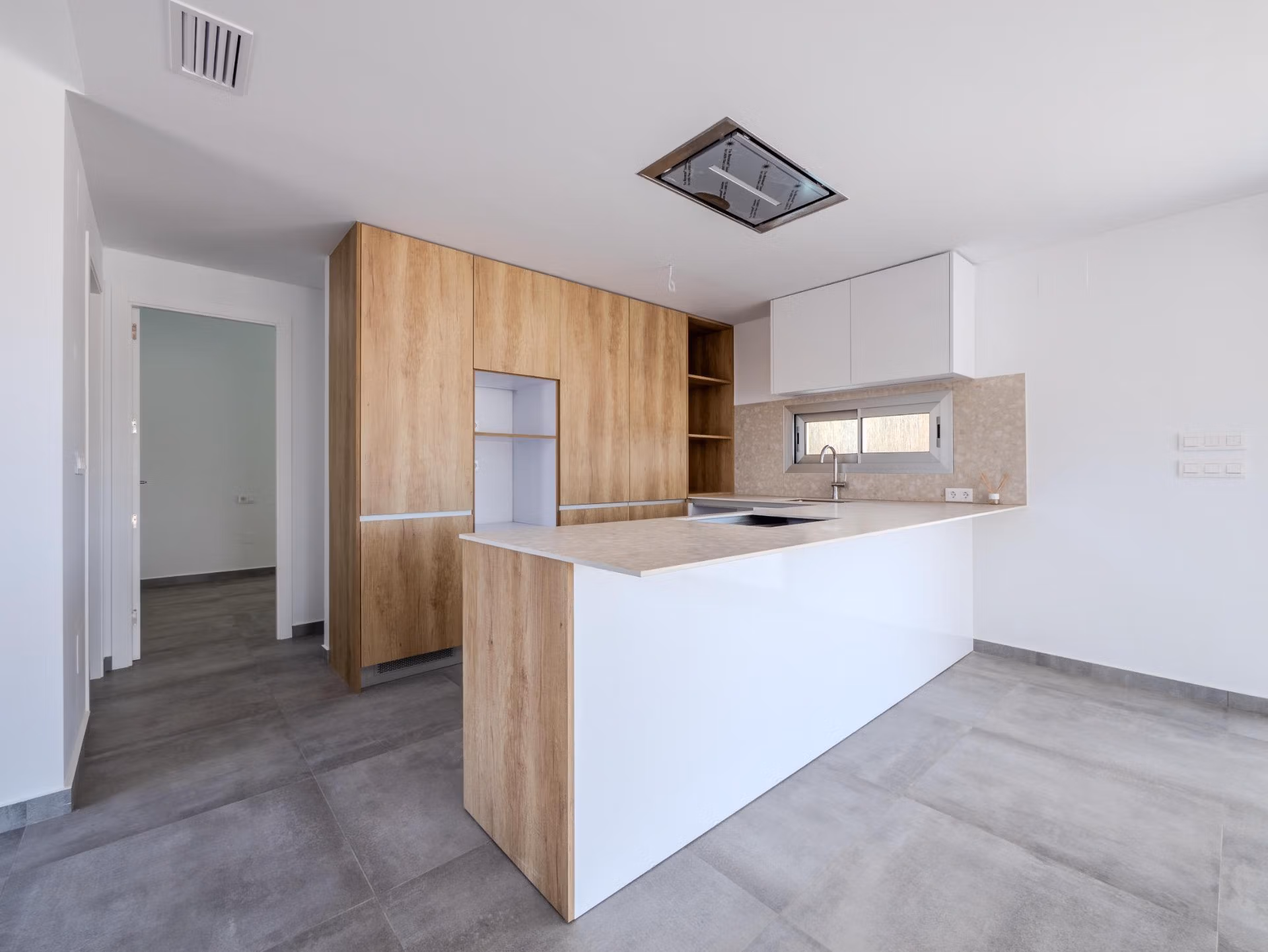 Modern, spacious kitchen with sleek wood cabinetry and bright open-plan design in a 4-bedroom villa in Algorfa, La Finca.