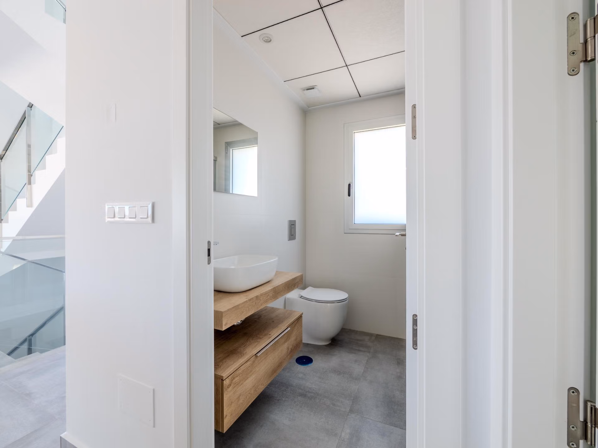 Bright, modern bathroom with sleek wood vanity and minimalist fixtures in a 4-bedroom villa in Algorfa, La Finca.