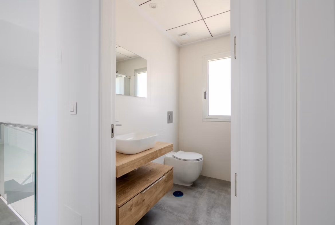 Bright modern bathroom with wooden vanity in spacious Key Ready 4 Bedroom Villa in Algorfa, La Finca.