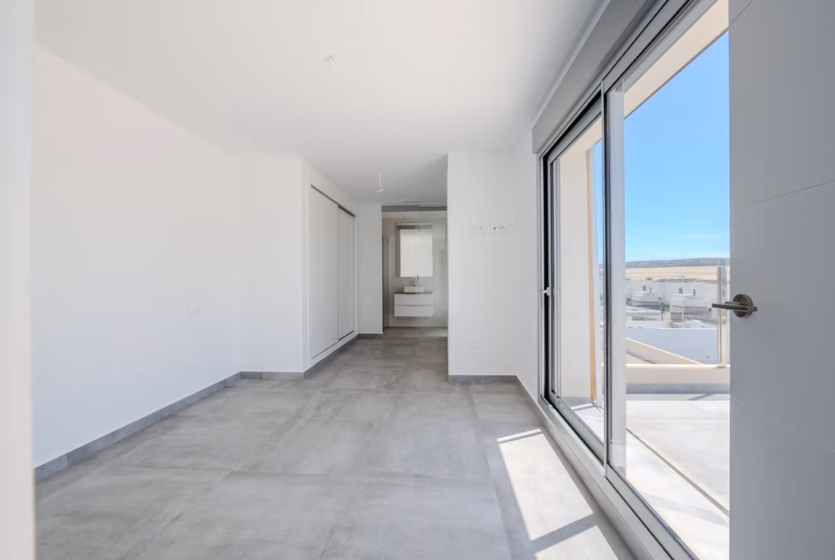 Bright, modern bedroom with sleek gray flooring and large sliding doors in a luxury 4-bedroom villa in Algorfa, La Finca.
