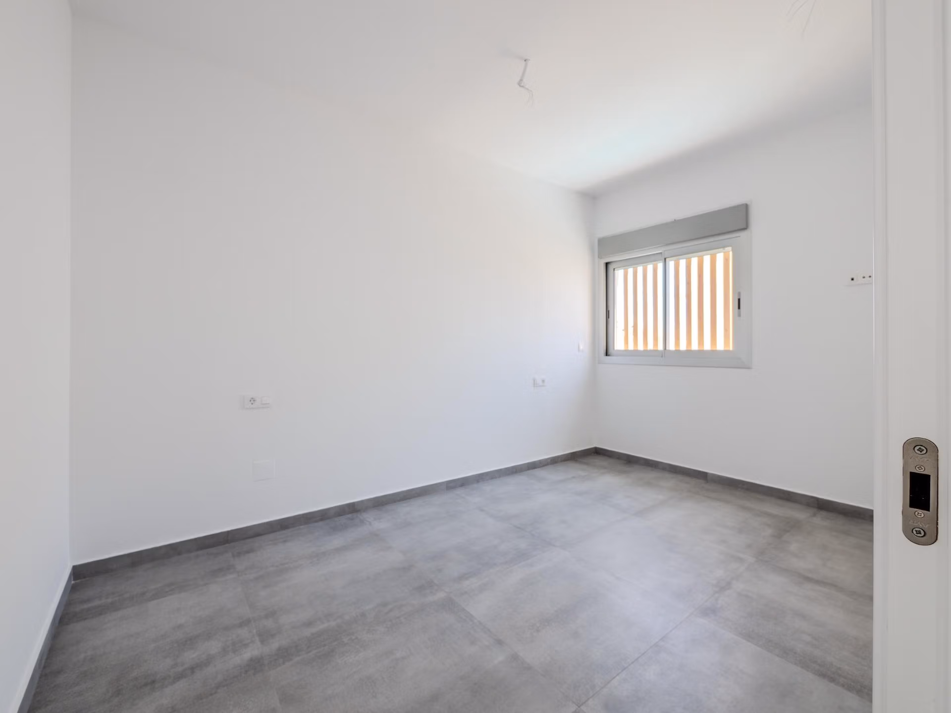 Minimalist bright bedroom with sleek gray flooring in a key-ready 4-bedroom villa in Algorfa, La Finca.