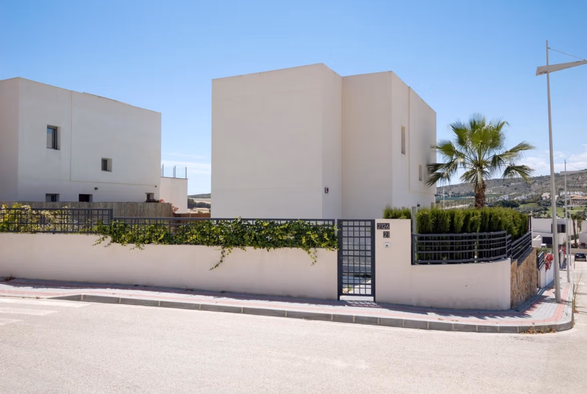 Modern white 4-bedroom villa exterior with private gated entrance and landscaped greenery in Algorfa, La Finca.