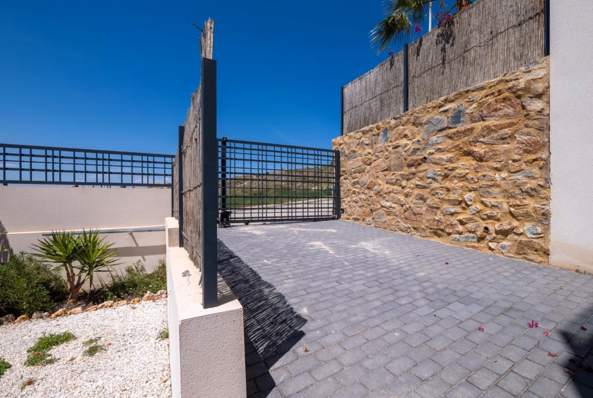 Private gated entrance with stone walls and modern driveway of a luxury 4-bedroom villa in Algorfa, La Finca golf views estate