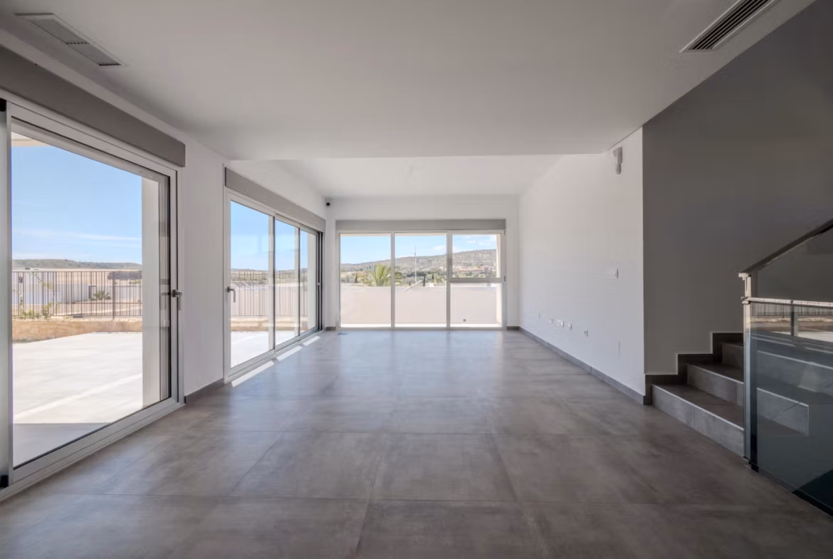 Bright, spacious living area with floor-to-ceiling windows and modern finishes in key-ready 4 bedroom villa in Algorfa, La Finca.
