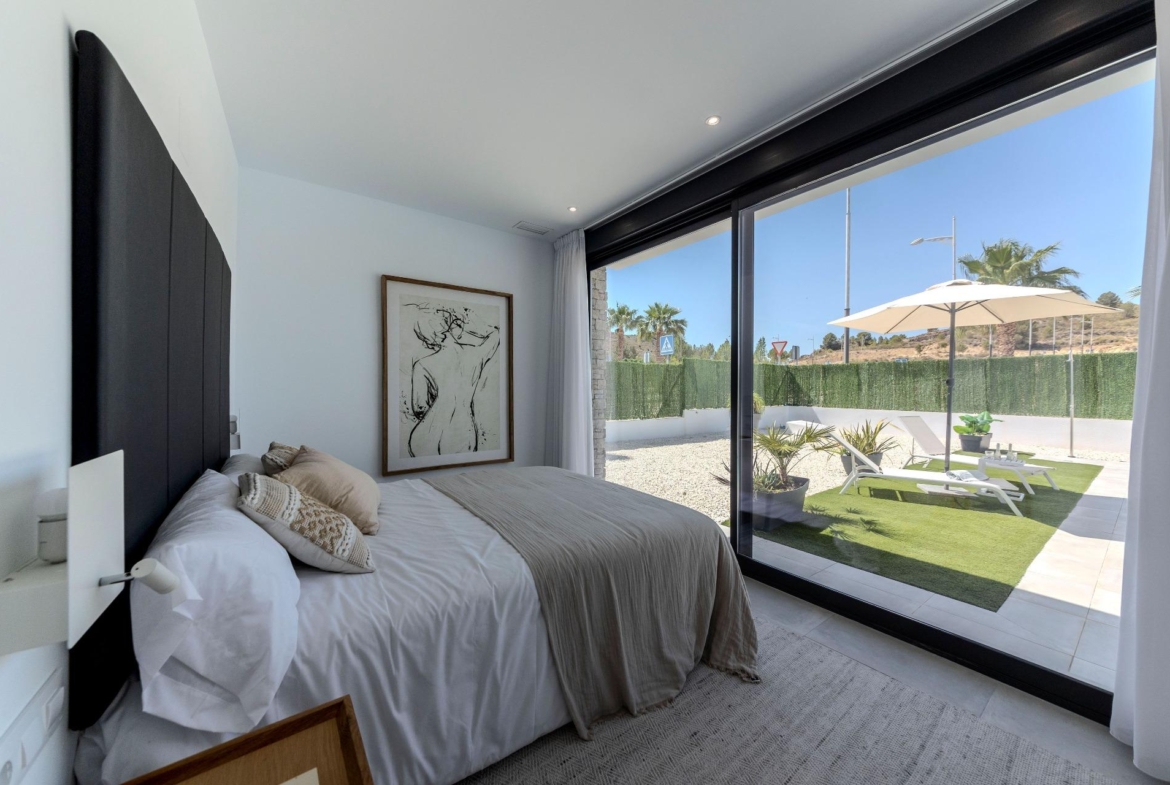 Bright modern bedroom with sliding glass doors opening to sun-drenched terrace in a 3-bedroom villa for sale in Calasparra, Murcia