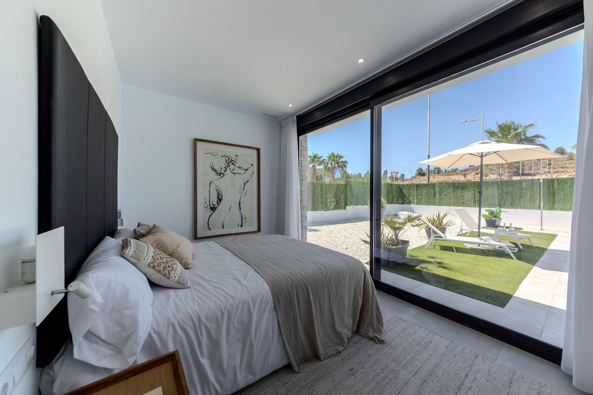 Bright modern bedroom with sliding glass doors opening to sun-drenched terrace in a 3-bedroom villa for sale in Calasparra, Murcia