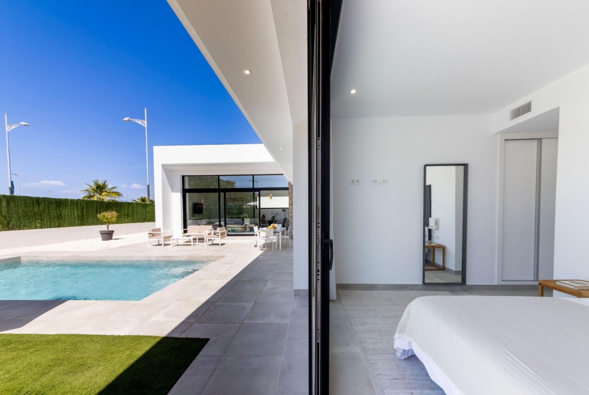 Bright modern bedroom with sleek decor opening to a sun-drenched private pool and spacious terrace in Calasparra villa.