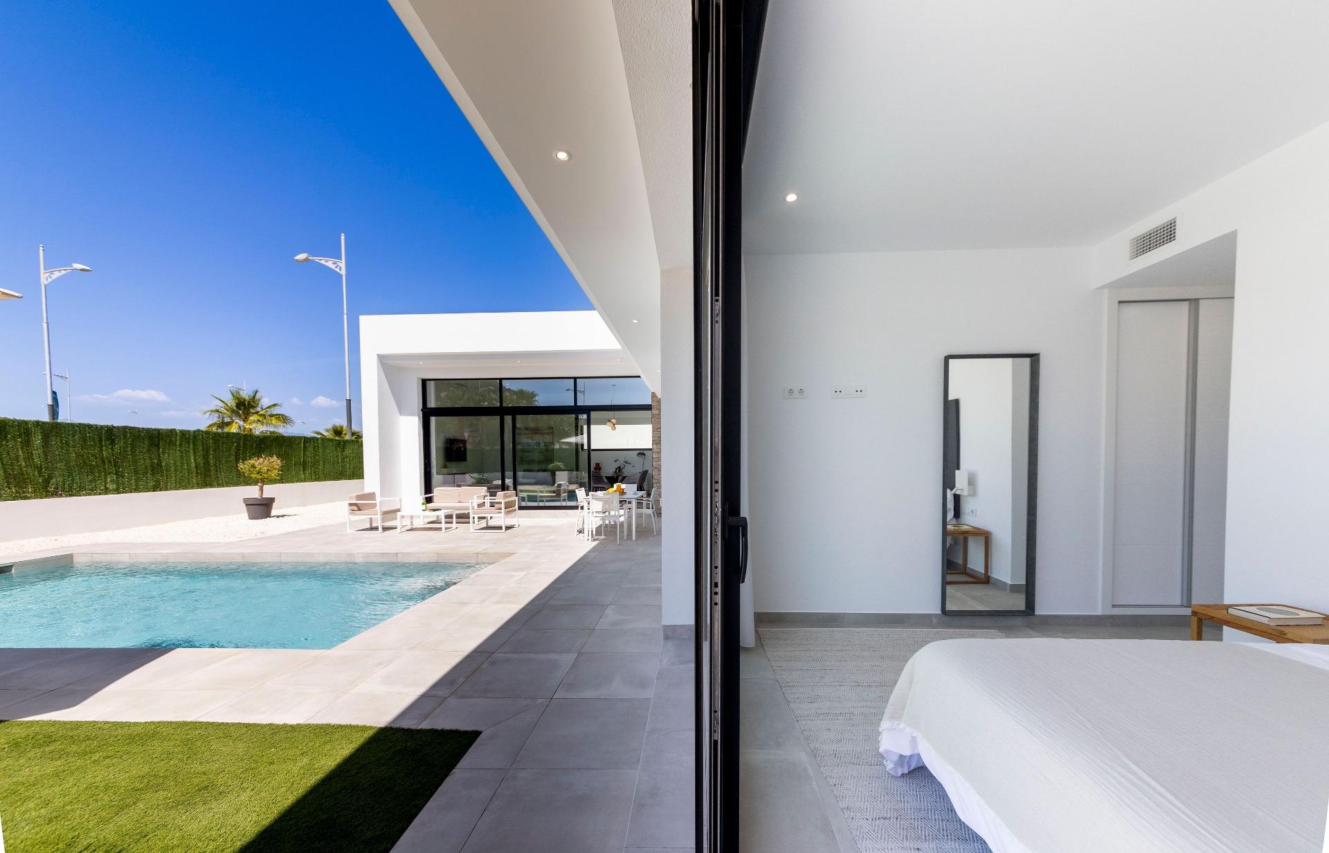 Bright modern bedroom with sleek decor opening to a sun-drenched private pool and spacious terrace in Calasparra villa.