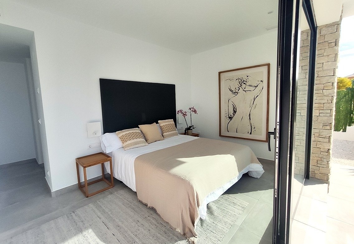 Bright, modern bedroom with large sliding doors and stylish decor in spacious new build 3-bedroom villa in Calasparra, Murcia.