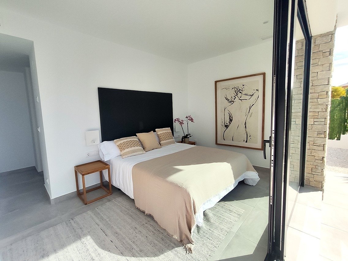 Bright, modern bedroom with large sliding doors and stylish decor in spacious new build 3-bedroom villa in Calasparra, Murcia.