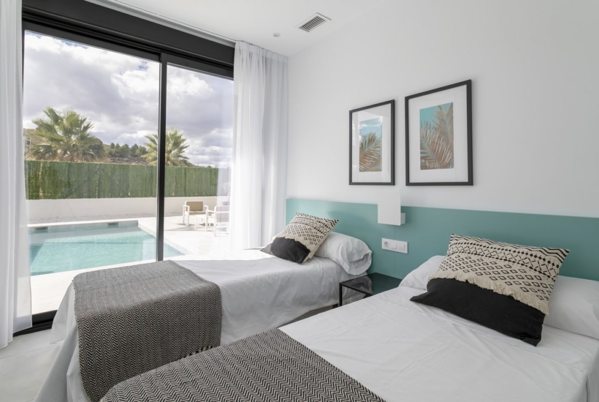 Bright, modern twin bedroom with sliding glass doors opening to a private pool in a spacious 3-bedroom villa in Calasparra, Murcia.