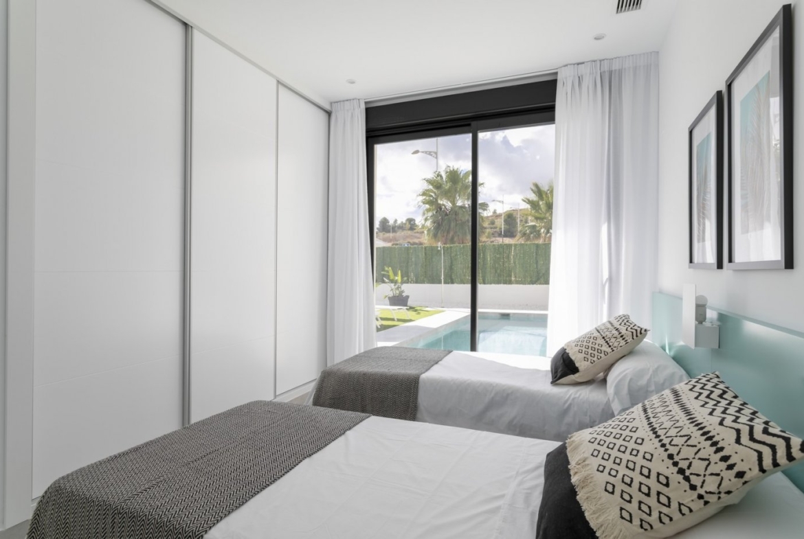 Bright, modern twin bedroom with sliding glass doors opening to a private pool in a spacious 3-bedroom villa in Calasparra, Murcia.