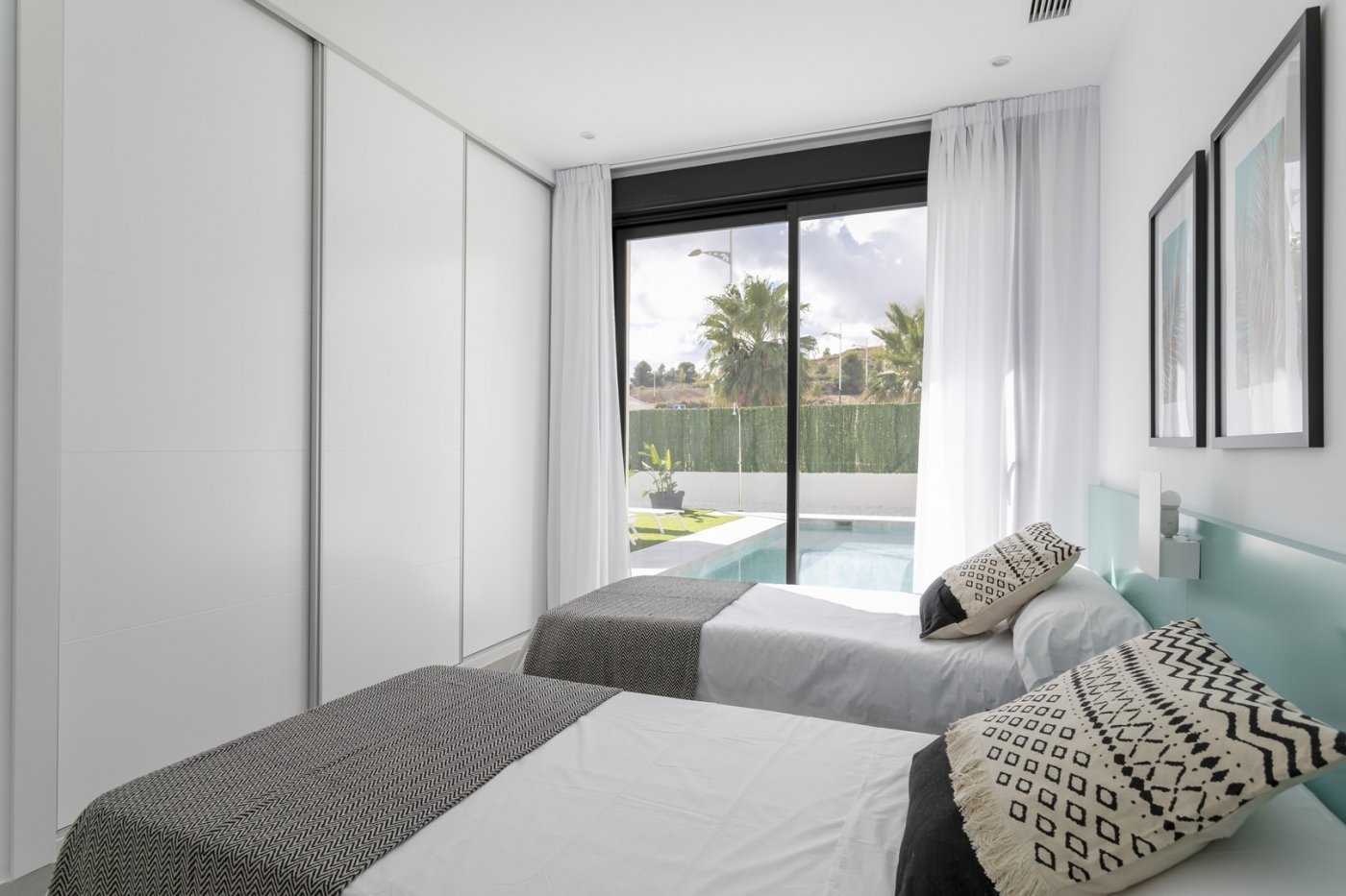Bright, modern twin bedroom with sliding glass doors opening to a private pool in a spacious 3-bedroom villa in Calasparra, Murcia.