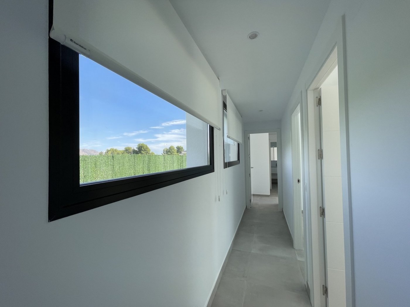 Bright, minimalist hallway with large windows showcasing serene views in a spacious new build 3-bedroom villa in Calasparra, Murcia