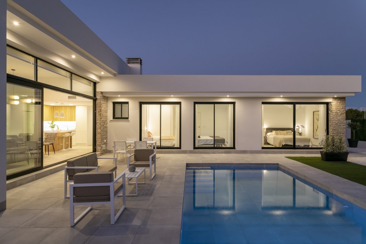 Modern spacious 3-bedroom villa with private pool and elegant outdoor seating in peaceful Calasparra, Murcia at dusk.