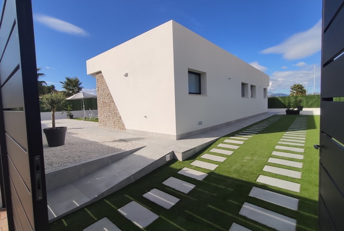 Sleek modern exterior of a spacious 3-bedroom villa with landscaped garden in Calasparra, Murcia, under clear blue skies.